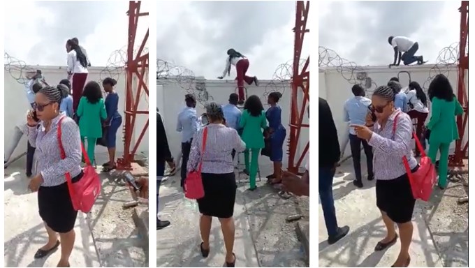 Bank officials scale fence to escape being lynched by angry mob (Watch video) - bank officials fence