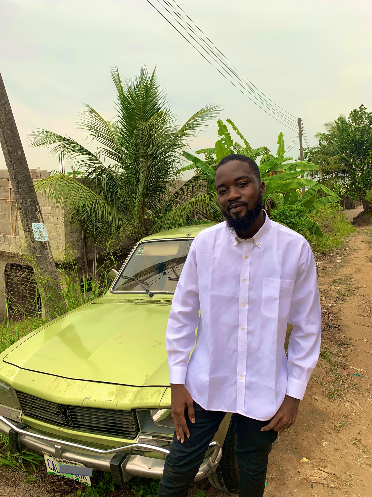 Young Nigerian man shows off old model car he purchased - man old peugeot 1